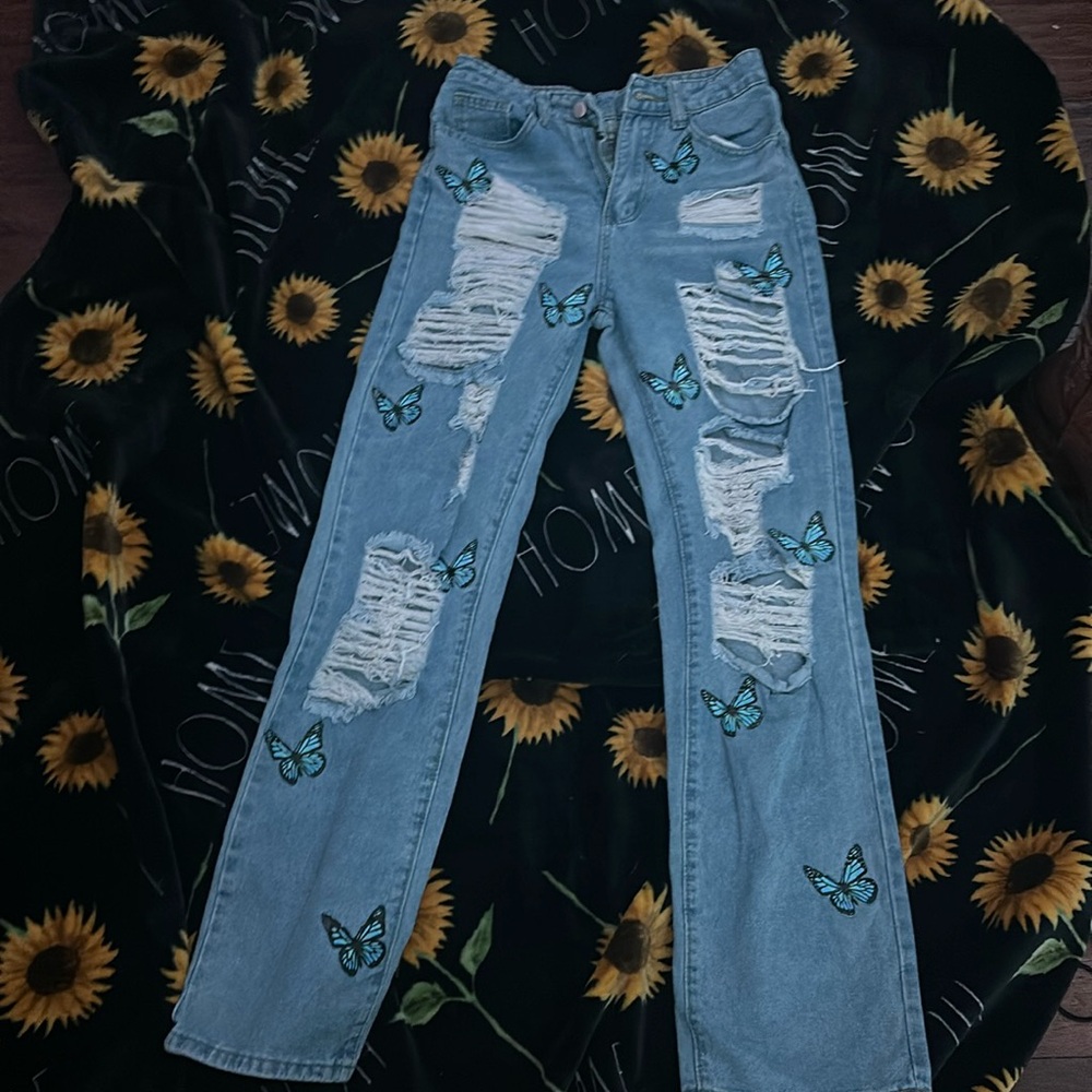 A pair f ripped jeans a, with a butterfly design, never worn before, great shape
